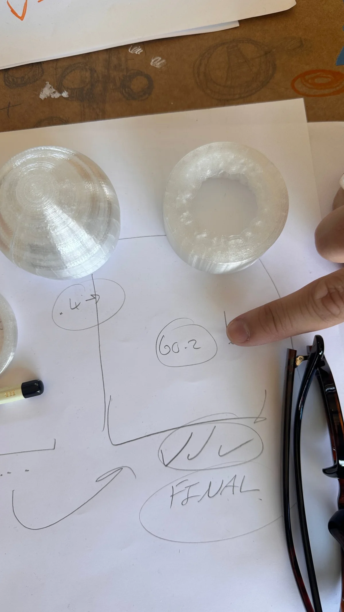 3D-printed end caps: the rounded final version next to an earlier flat one