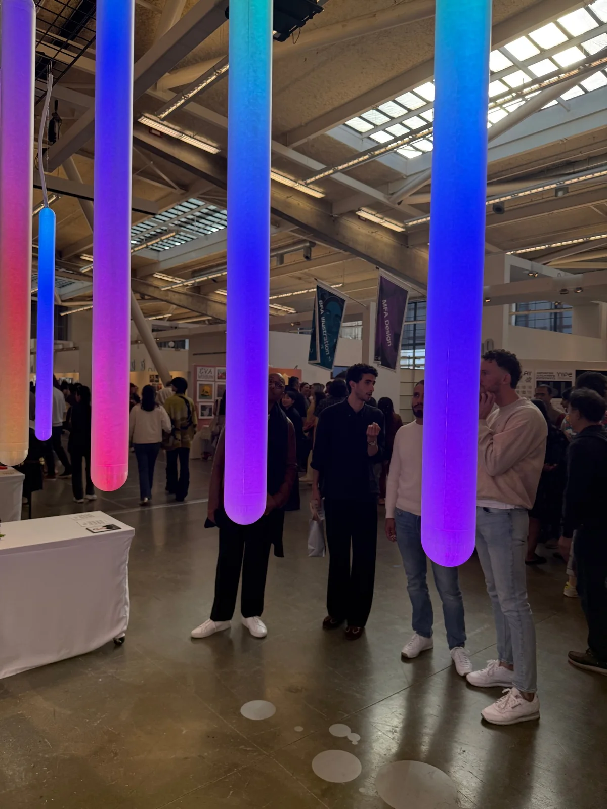 Visitors under the glowing tubes at the exhibition